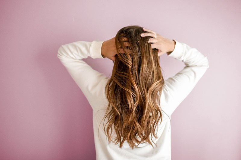 A lady ruffling her long locks. Maybe she's a Keranique fan.