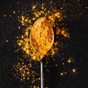 A spoon holding turmeric powder