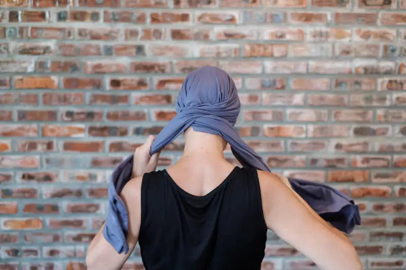 Tying scarf behind head