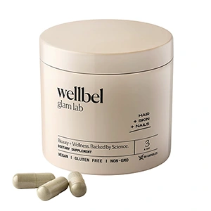 A photo of Wellbell Hair Supplements with three tablets outside the bottle