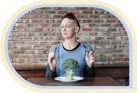 Girl with Alopecia eating brocolli